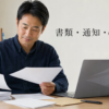 書類とノートパソコンを前に国税手続きの準備を分ける人物