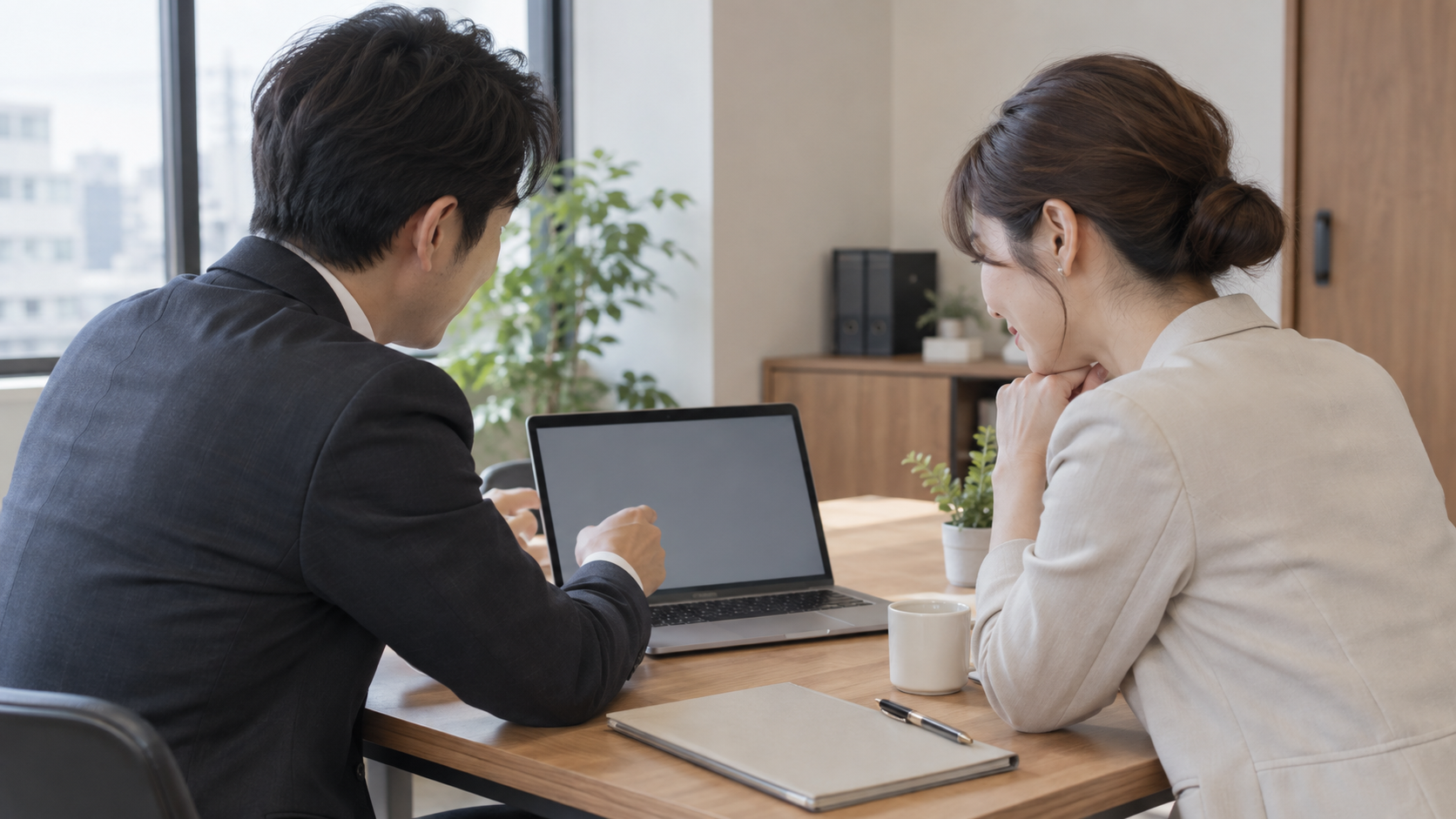 ノートパソコンを見ながら決済方法の切替を話し合う二人の事業者