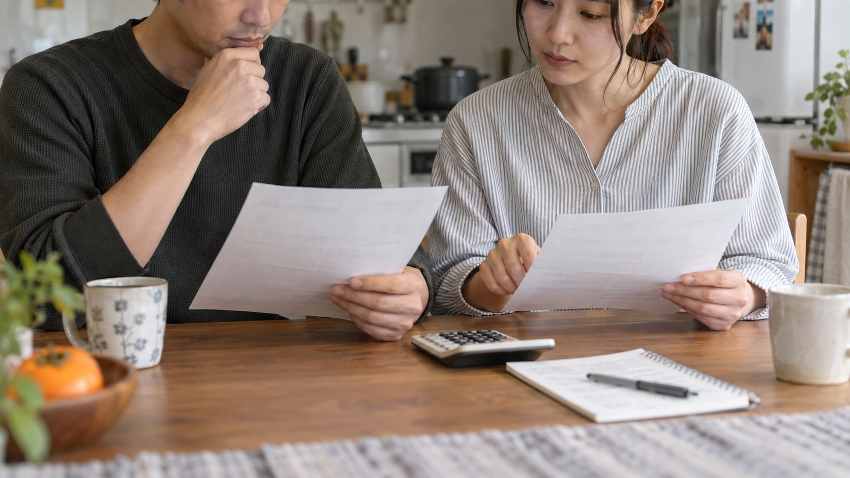 料金の書類と電卓を前に家庭で比較する様子
